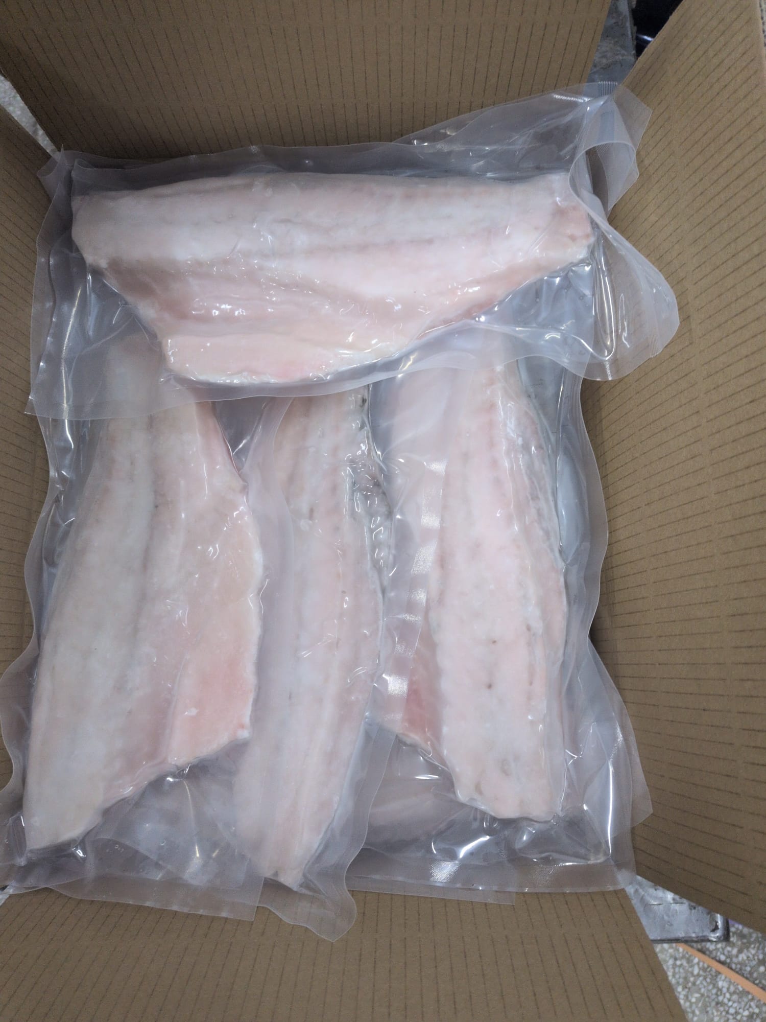 Skin-off vacuum-packed barramundi fillets in master carton.